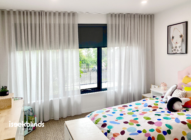 Bright and colourful child's bedroom featuring light grey sheer curtains with black blockout roller blinds behind them. 
