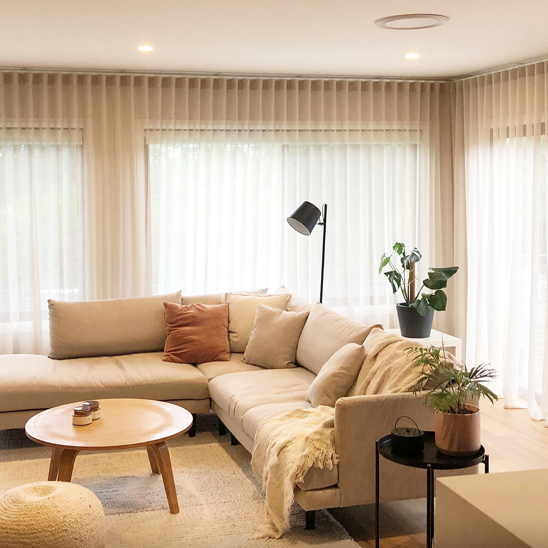 Beautifully styled living room with wall to wall neutral sheer curtains 