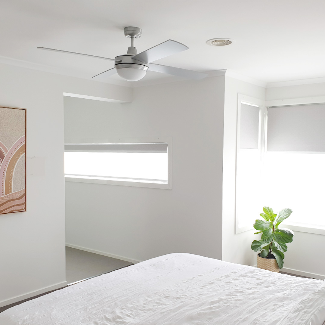 White double motorised roller blinds in a beautifully styled bedroom with lots of natural light
