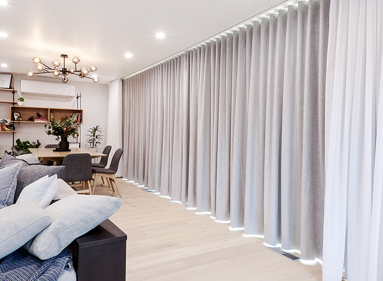 A wall of white sheer curtains with grey blockout curtains behind them.
